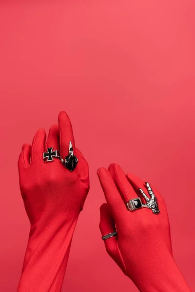 Partial view of female hands in gloves with rings isolated on red — Stock Photo