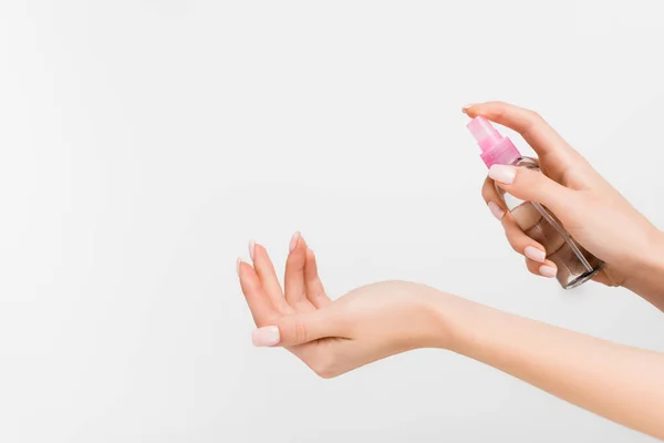 Vista cortada da mulher segurando frasco de spray com líquido isolado em branco — Fotografia de Stock