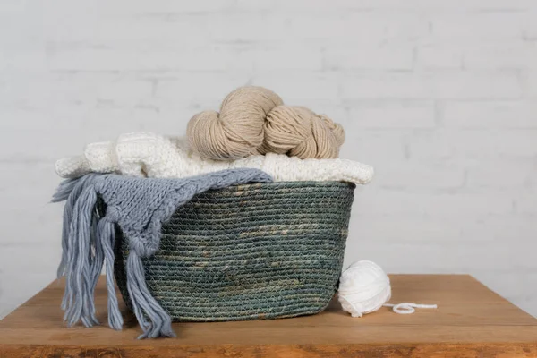 Fios de lã na cesta na mesa de madeira no fundo branco — Fotografia de Stock