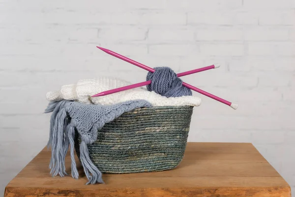 Cesta con hilo, innecesario e hilo sobre tabla de madera sobre fondo blanco - foto de stock