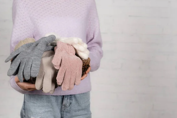 Vue recadrée de la femme tenant panier avec des gants doux sur fond blanc — Photo de stock