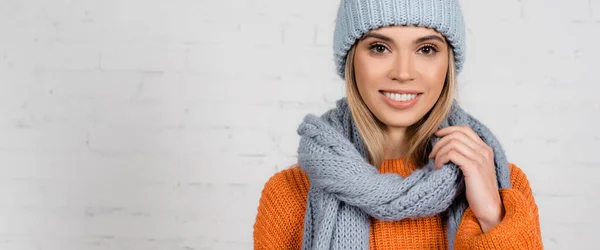 Smiling woman in warm hat, sweater and scarf on white background, banner — Stock Photo