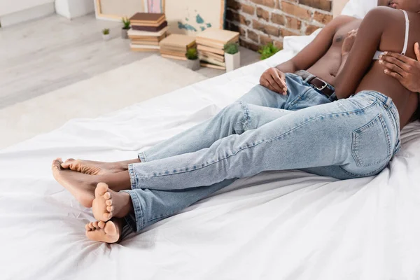 Coupé vue de sexy couple afro-américain couché sur le lit à la maison — Photo de stock