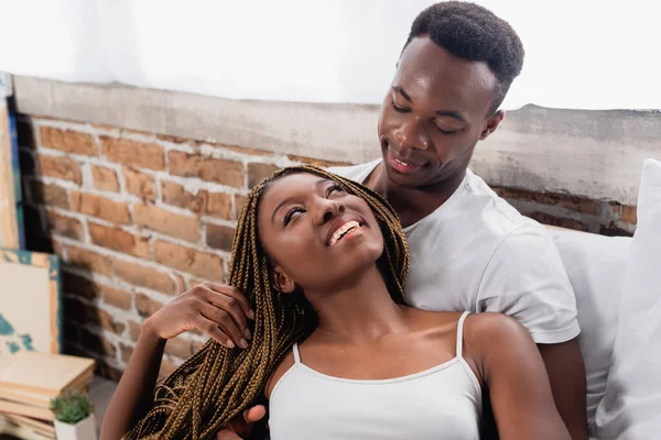 Positiva donna afro-americana che guarda il fidanzato a casa — Foto stock