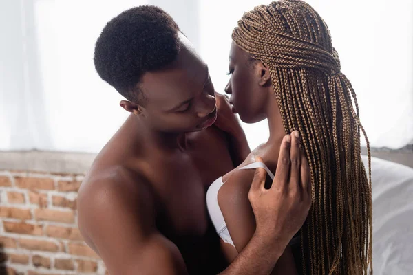 Shirtless african american man undressing sexy woman in bra — Stock Photo