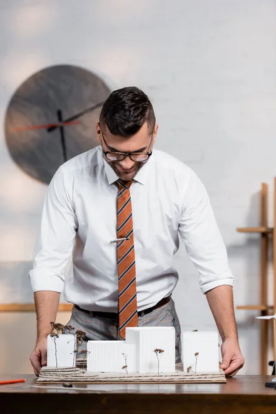 Architecte souriant regardant le projet architectural dans le bureau — Photo de stock