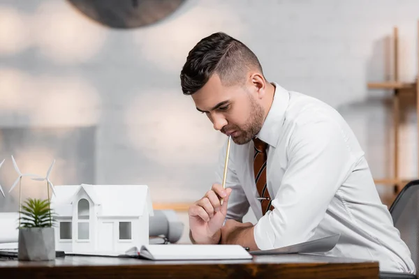 Arquitecto reflexivo que trabaja en el proyecto en la agencia de arquitectura - foto de stock