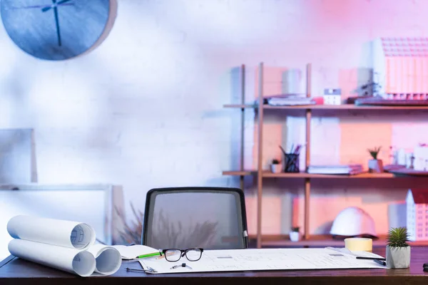 Blueprints and eyeglasses on desk in architectural agency — Stock Photo