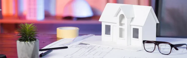 Modelo da casa perto de óculos e planta sobre mesa na agência de arquitetura, banner — Fotografia de Stock