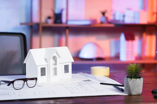 Modelo de casa cerca de anteojos y anteojos en el escritorio en la agencia de arquitectura - foto de stock