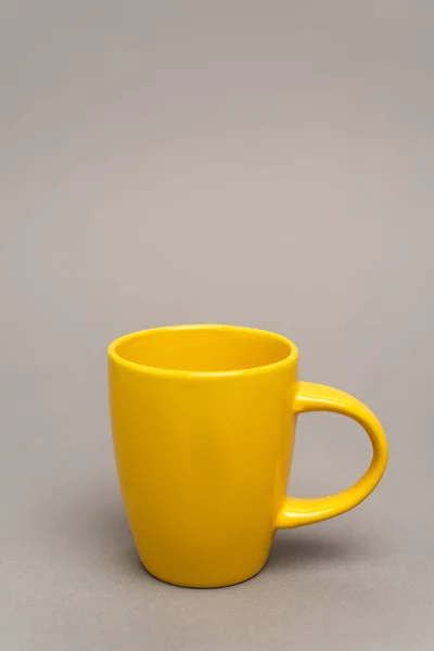 Taza amarilla con bebida caliente en gris con espacio de copia — Stock Photo