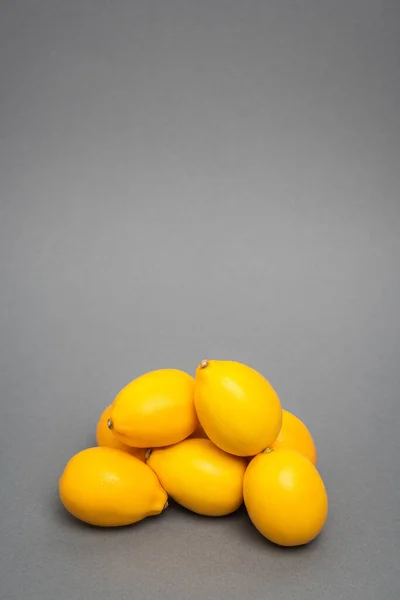 Limoni freschi e gialli su fondo grigio — Foto stock