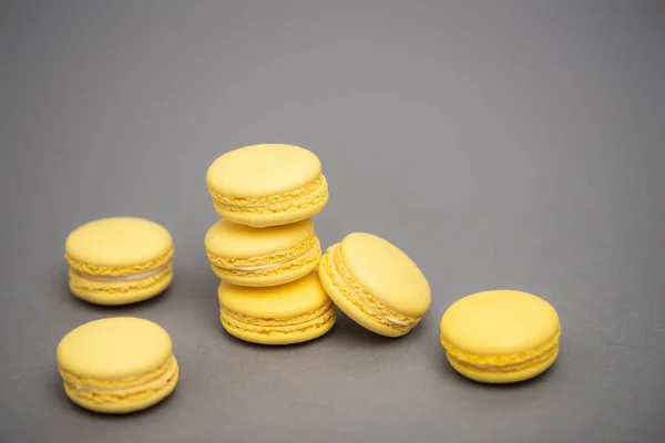 Süße gelbe Macarons auf grauem Hintergrund — Stockfoto