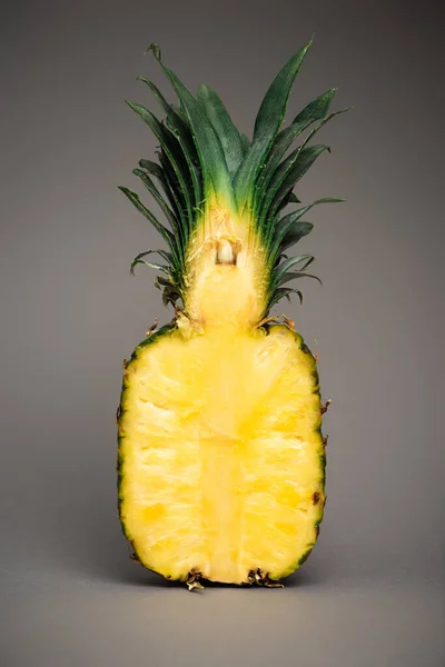 Половина спелого и свежего ананаса на сером — стоковое фото