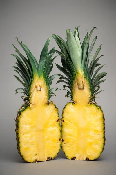 Hälften saftig-süßer Ananas auf grau — Stockfoto