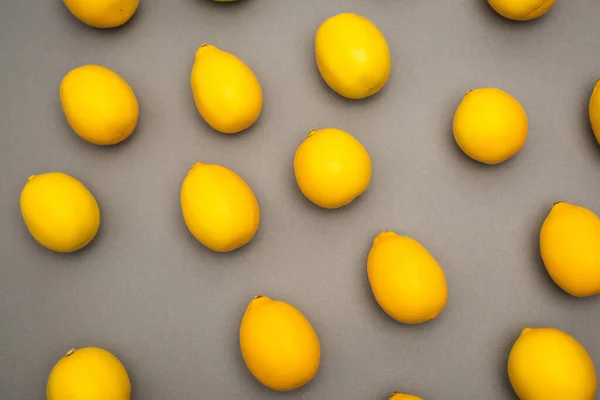 High angle view of fresh and yellow lemons on grey background — Stock Photo