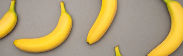 Top view of ripe yellow bananas on grey background, banner — Stock Photo