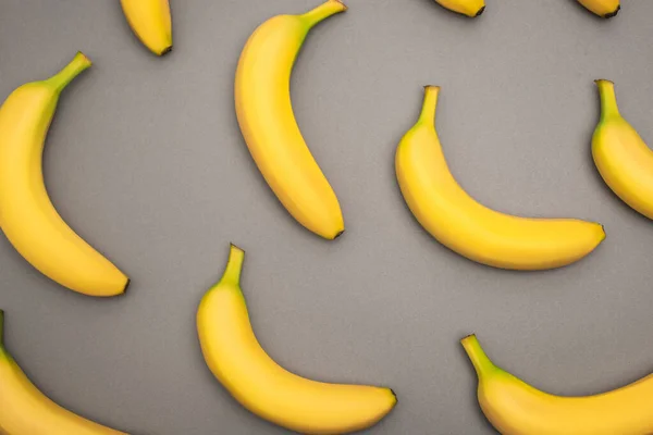 Draufsicht auf reife gelbe Bananen auf grauem Hintergrund — Stockfoto