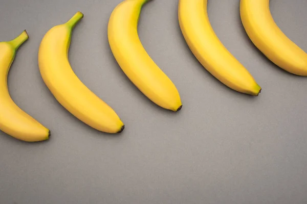Vista dall'alto di banane mature gialle su sfondo grigio — Foto stock
