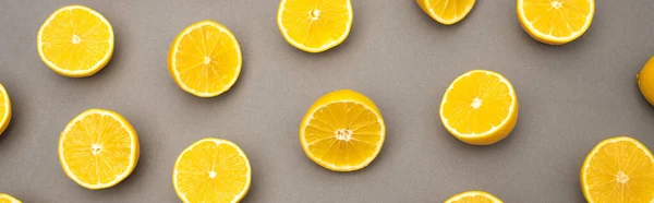 Parte superior de mitades de limones frescos y maduros en gris, bandera - foto de stock