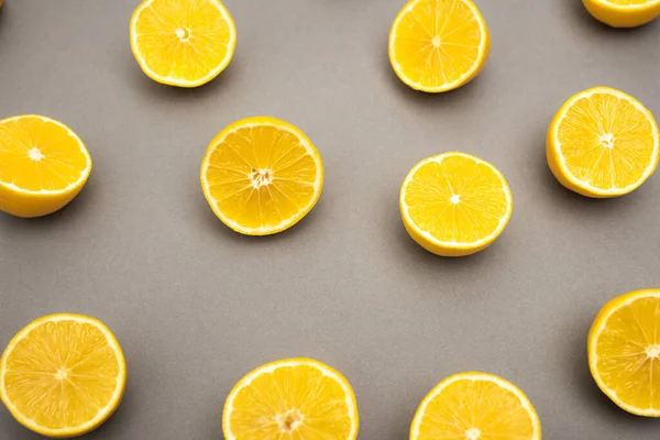 Top view of halves of fresh and ripe lemons on grey — Stock Photo