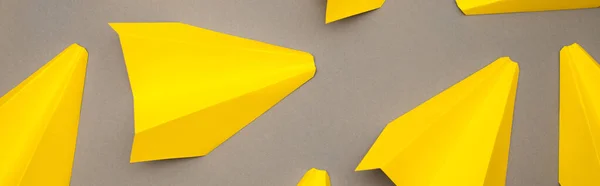 Top view of yellow paper planes on grey background, banner — Stock Photo