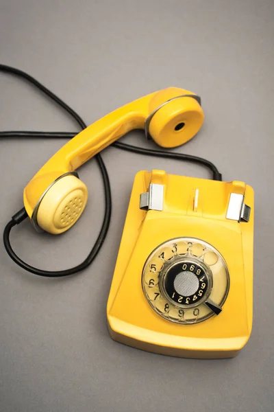 Вид сверху на ретро и желтый телефон на сером фоне — стоковое фото