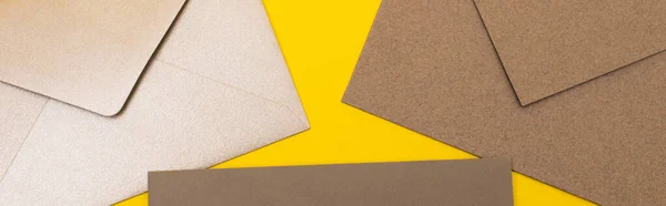 Vue de dessus des enveloppes en papier isolées sur jaune, bannière — Photo de stock