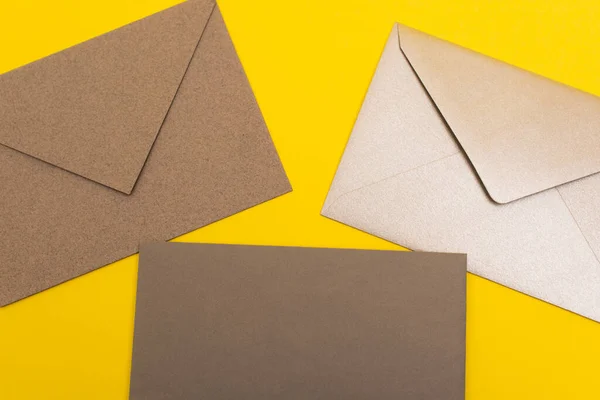 Vista superior de envelopes de papel isolados em amarelo — Fotografia de Stock