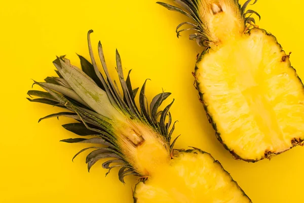 Vue de dessus de moitiés d'ananas juteux et sucrés isolés sur jaune — Photo de stock