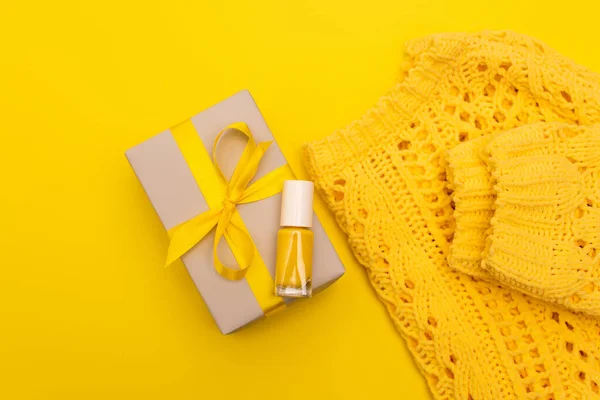 Ansicht von oben Nagellack auf eingewickeltem Geschenk in der Nähe Pullover isoliert auf gelb — Stockfoto