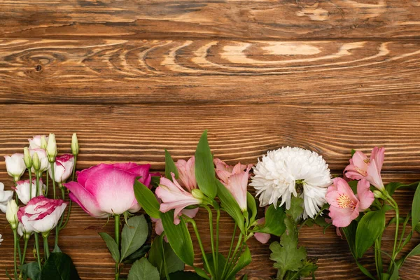 Draufsicht auf die Vielfalt der rosa und weiß blühenden Blumen auf der Holzoberfläche — Stockfoto