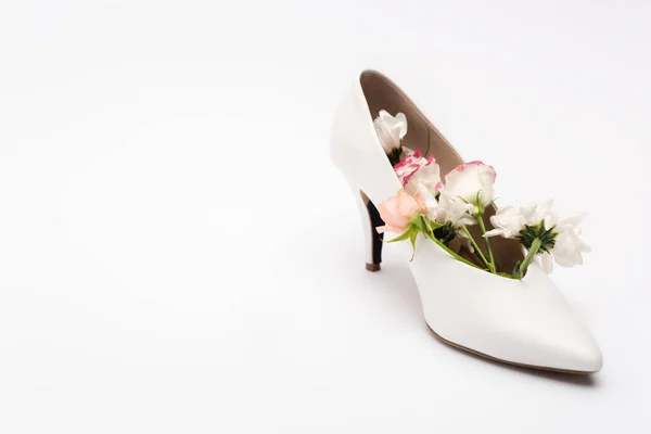 Diferentes flores en zapato femenino en blanco con espacio de copia - foto de stock