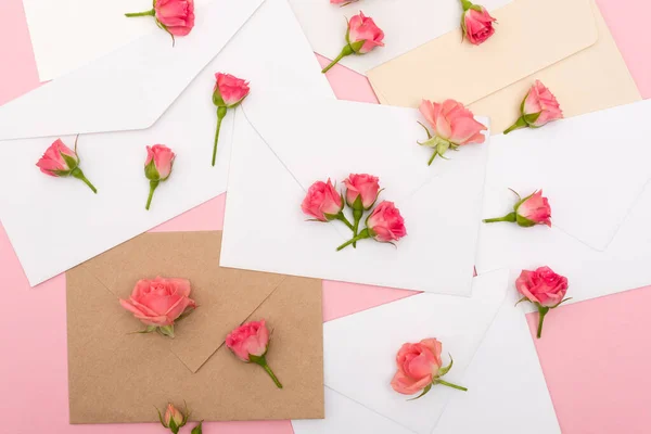 Vista superior de pequenas rosas de chá em envelopes e letras — Fotografia de Stock
