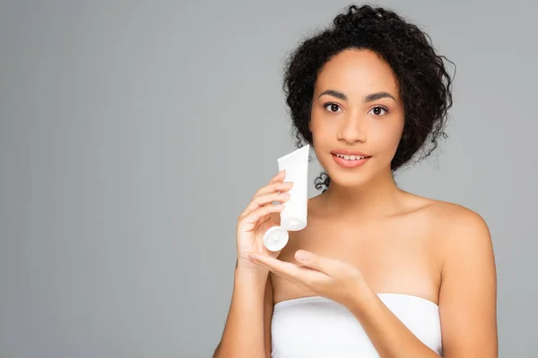 African american woman with perfect skin holding tube with cleansing foam isolated on grey — Stock Photo