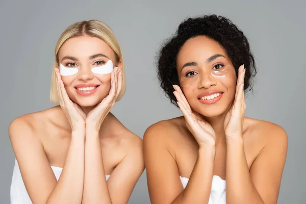 Mulheres multiétnicas sorridentes em manchas oculares isoladas em cinza — Fotografia de Stock