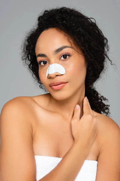 Afroamerikanerin mit Reinigungsstreifen auf der Nase blickt isoliert auf graue Kamera — Stockfoto