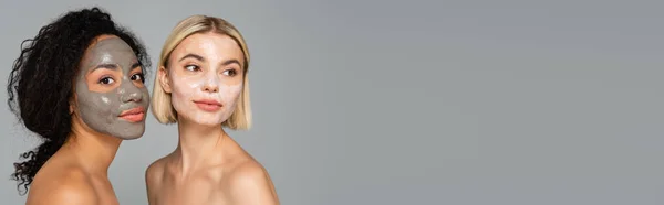 Interrassische Frauen in Gesichtsmasken isoliert auf grau mit Kopierraum, Banner — Stockfoto