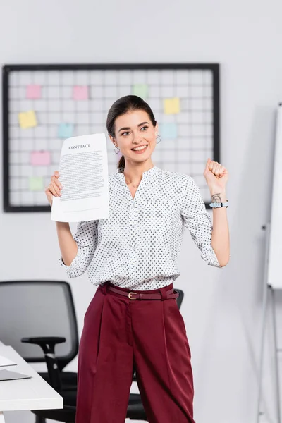 Feliz empresária segurando contrato no escritório — Fotografia de Stock