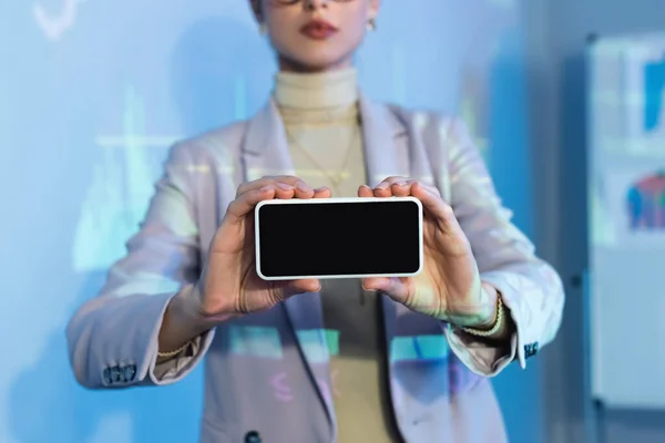 Vista parcial de la mujer de negocios sosteniendo teléfono inteligente con pantalla en blanco — Stock Photo