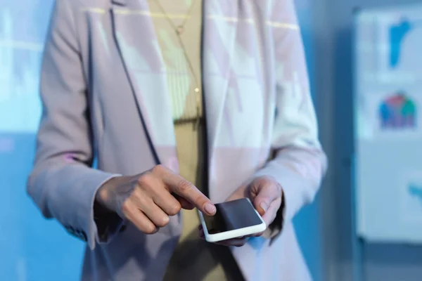 Vista parcial de la empresaria apuntando con el dedo al teléfono inteligente con pantalla en blanco - foto de stock