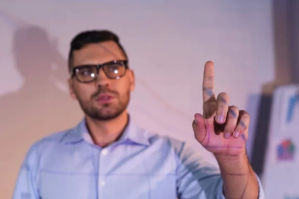 Розмитий бізнесмен в окулярах, вказуючи пальцем в офісі — стокове фото