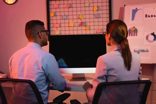 Gente de negocios sentada en el escritorio con monitor de computadora con pantalla en blanco - foto de stock