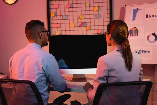 Business people sitting at desk with computer monitor with blank screen — Stock Photo