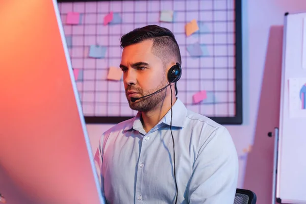 Opérateur dans casque regardant moniteur d'ordinateur — Photo de stock