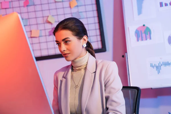 Attrayant femme d'affaires regardant moniteur d'ordinateur dans le bureau — Photo de stock