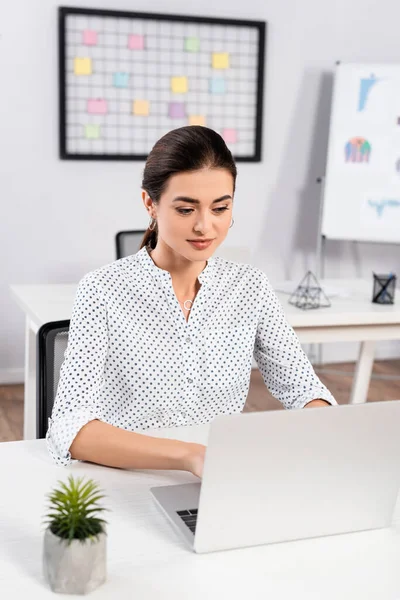 Donna d'affari digitando sul computer portatile sulla scrivania in ufficio — Foto stock