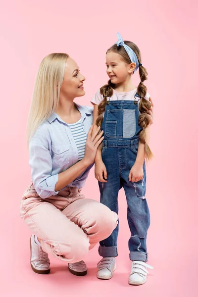 Happy mother and daughter looking at each other on pink — Stock Photo