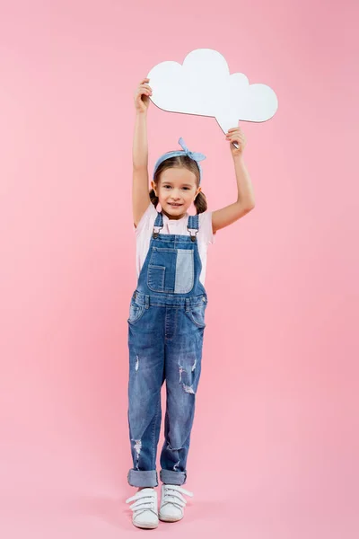 Full length of cheerful kid holding thought bubble above head on pink — Stock Photo