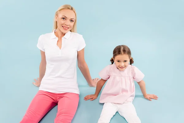 Glückliche Mutter und Kind auf blauem Hintergrund — Stockfoto